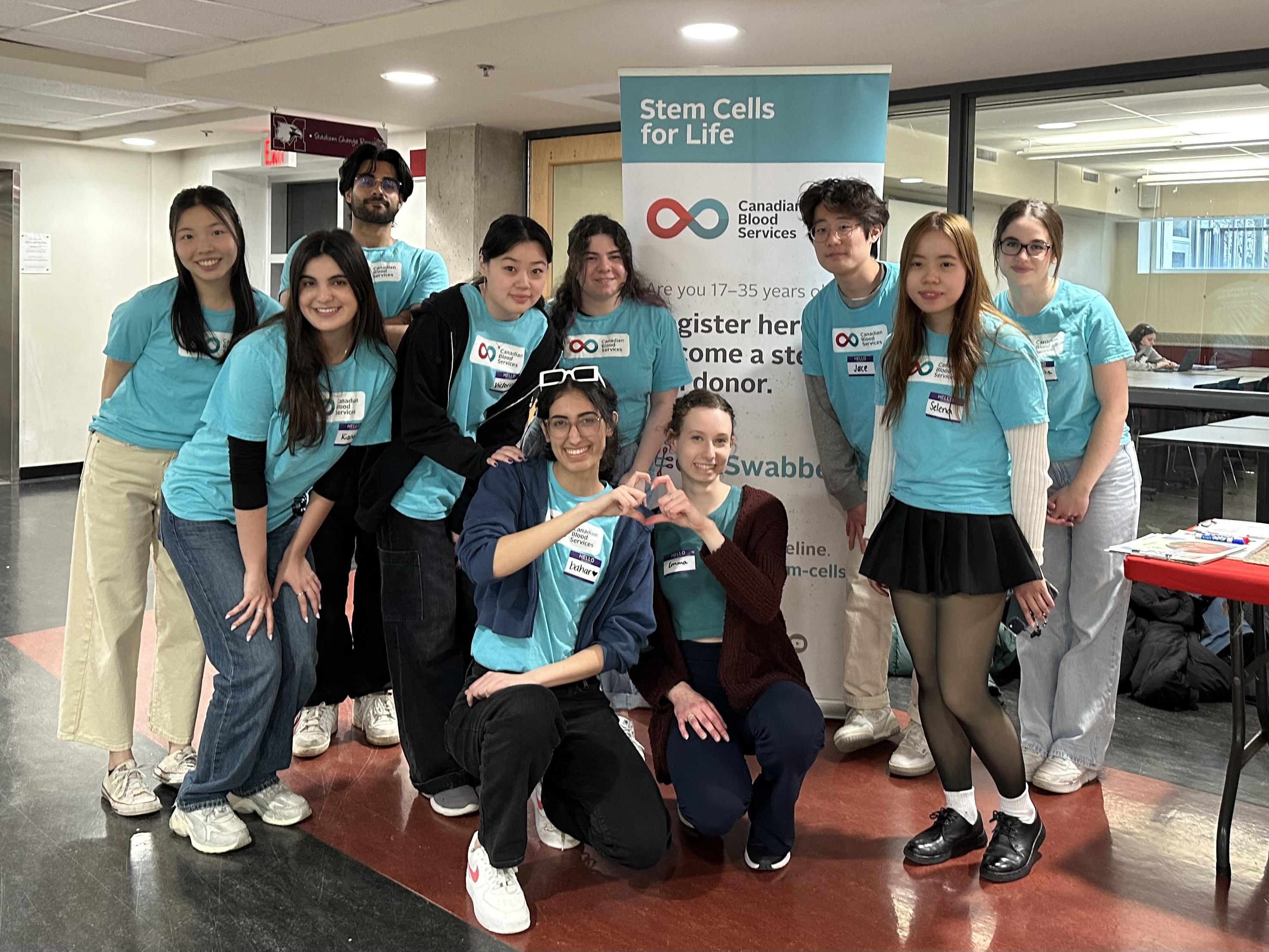 IDSL volunteers in teal shirts at a McMaster University stem cell donor drive